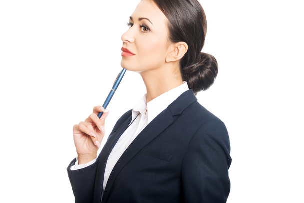Portrait of businesswoman holding pen under chin - Foto, Bild