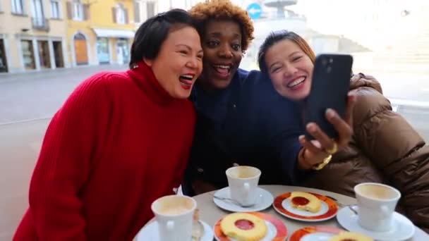 Ryhmä afrikkalaisia ja aasialaisia keski-ikäisiä naisia ottamassa itsestään kuvaa aamiaisen aikana - Materiaali, video
