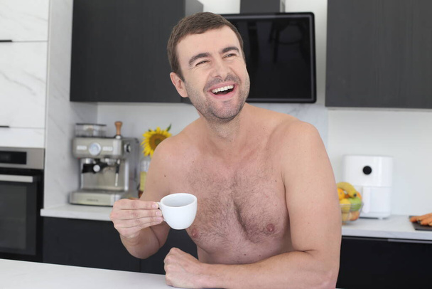 portrét pohledného mladého muže bez košile s šálkem kávy v kuchyni - Fotografie, Obrázek