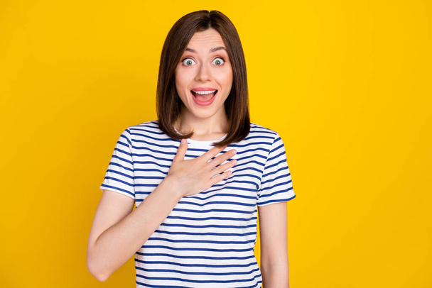 Photo portrait of cute young lady hand touch chest cant believe win lottery dressed trendy striped look isolated on yellow color background. - Φωτογραφία, εικόνα