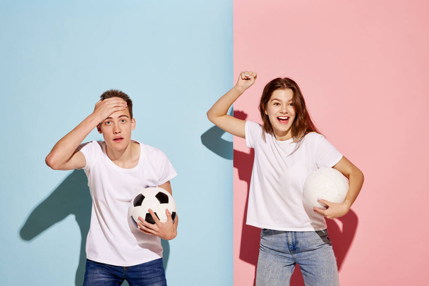 Portrait of young man and woman, sport fans posing with football ball isolated over blue-pink background. Joy and failure. Concept of youth culture, fashion, relationship, emotions. Copy space for ad - Photo, Image