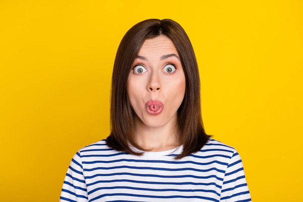 Photo portrait of lovely young woman staring rolled tongue out humorous dressed trendy striped outfit isolated on yellow color background. - Φωτογραφία, εικόνα