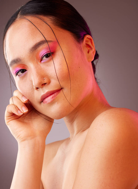 Portrait, Asian woman and makeup for natural beauty, wellness and happy with studio background for skincare. Cosmetics, young girl and body care for organic facial, smooth skin and creative neon face. - Photo, Image
