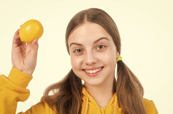 vitamin and dieting. child eating healthy food. childhood health. citrus fruits. natural organic fresh lemon. healthy life. diet and kid skin beauty. happy teen girl with lemon citrus fruit. - 写真・画像