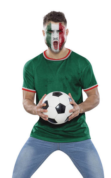 Soccer fan man with jersey and face painted with the flag of the Mexico team screaming with emotion on white background. - Photo, image
