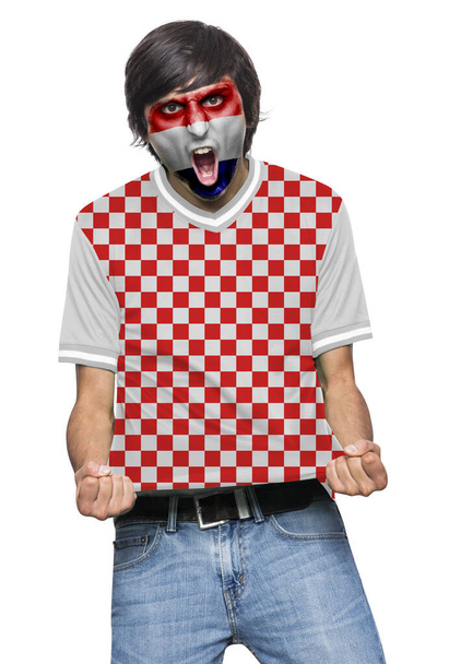 Soccer fan man with jersey and face painted with the flag of the Croatia team screaming with emotion on white background. - Fotó, kép