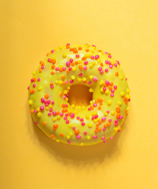 Top view of Mango donut with icing on pastel yellow background - 写真・画像