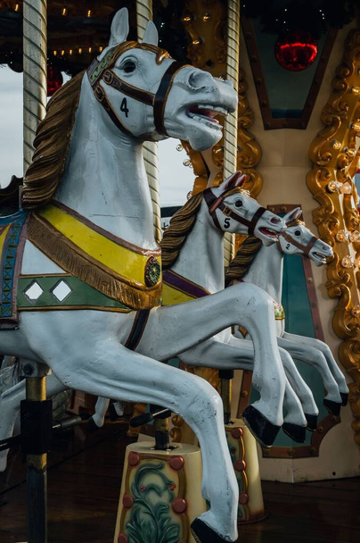 A vertical closeup shot of horses on a merry-go-round carousel ride - Photo, image