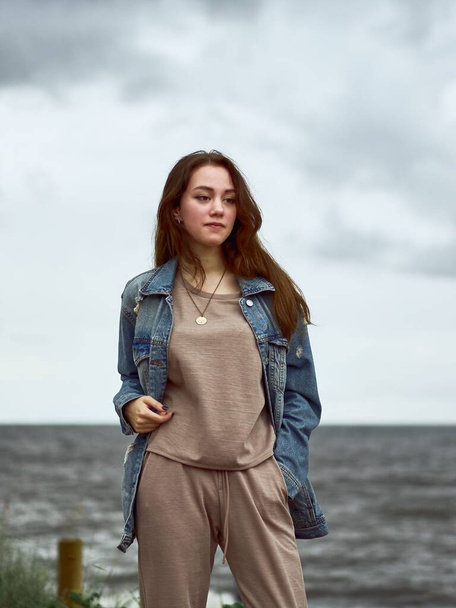 An attractive white Caucasian woman posing at the shore in a vertical shot - Valokuva, kuva