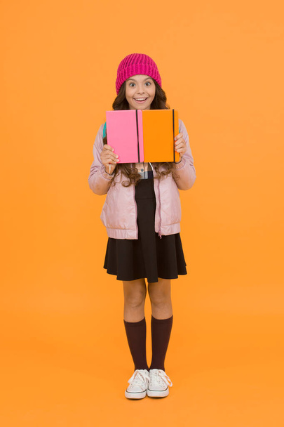 School girl. Happy girl back to school in autumn. Little girl borrow books in library. Small girl smile in formal school uniform. Education and learning. Knowledge and information. - 写真・画像