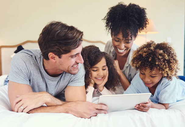 The kids simple love their cartoons. a family using a digital tablet together at home - Foto, Imagen