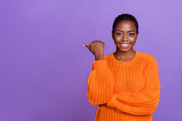 Фотографія молодої дівчини вказує на великий палець порожній простір рекламної пропозиції вибрати ізольовані на фіолетовому кольоровому фоні
. - Фото, зображення