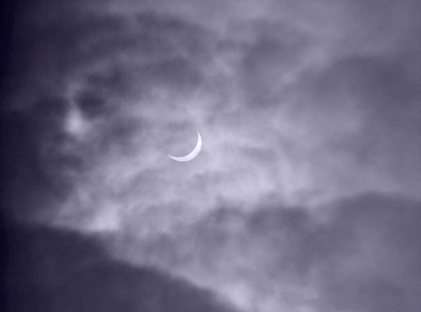 英国で太陽の2015年の日食の写真を撮るときに捉えられた雲の中の幽霊の顔の画像 - 写真・画像