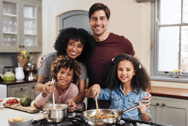 O jantar estará pronto daqui a pouco. uma família de quatro cozinhando juntos em sua cozinha em casa - Foto, Imagem