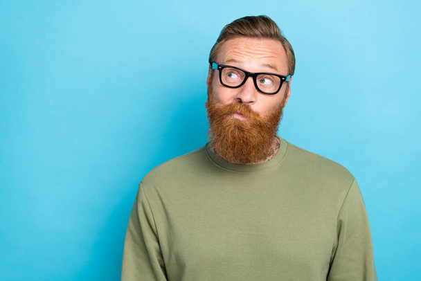 Photo of pensive man wear trendy khaki sweater interested look empty space hmm ponder decision dilemma isolated on blue color background. - Photo, Image