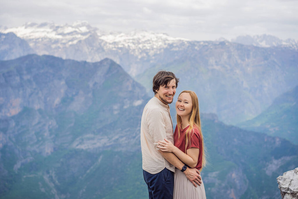 Man and woman happy couple tourists on background of Breathtaking panoramic view of the Grlo Sokolovo gorge in Montenegro. In the foreground is a mountain, the flat side of which forms a cliff, and - Fotó, kép