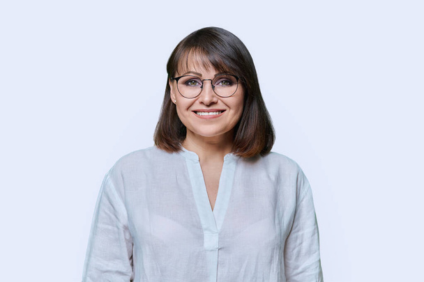 Laughing smiling middle aged female looking at camera on light studio background. Attractive happy mature woman with toothy smile in glasses. Success, joy, positivity, lifestyle, 40s people concept - Zdjęcie, obraz