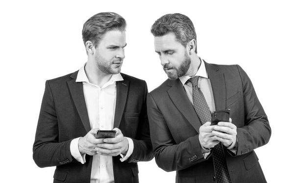 two business colleagues in suit use phone for negotiation isolated on white, online communication. - Foto, Imagen