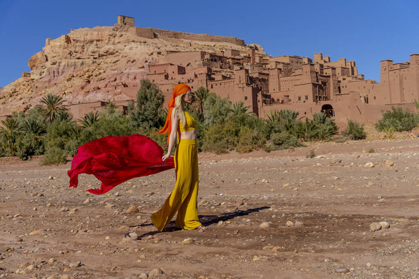 Ein wunderschönes Modell posiert im Freien in der Nähe von Ait Ben Haddou, einem UNESCO-Weltkulturerbe in Marokko, Afrika - Foto, Bild