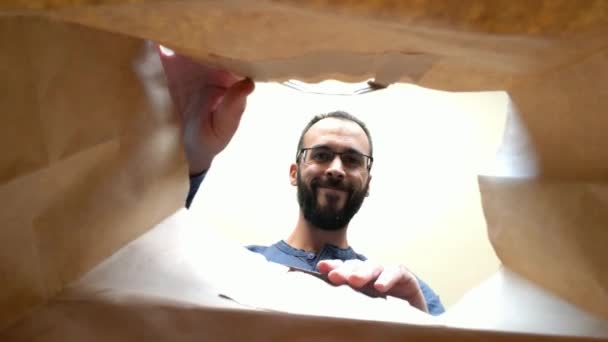 Pohled zevnitř papírový sáček vousatého muže a sklenice, jak si doma vyndavají jídlo - Záběry, video