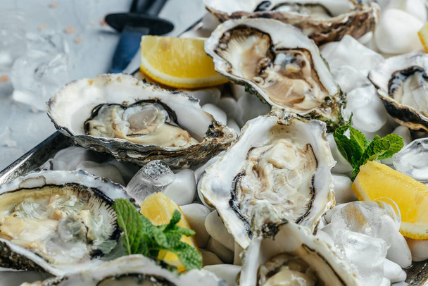 Fresh raw oysters with champagne in restaurant. Fresh Oysters with lime, lemon and ice. - Foto, Imagem