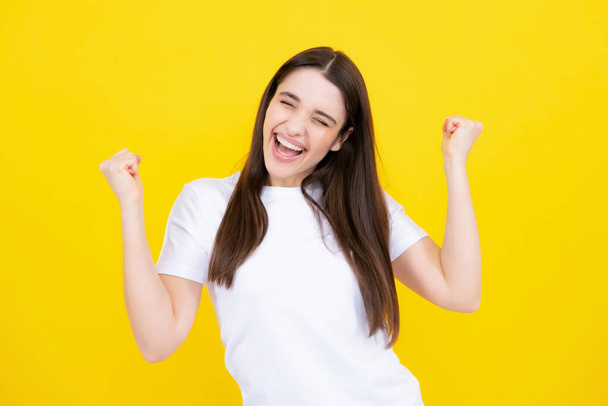 Cheerful beautiful young woman showing winner gesture. Girl celebrating crazy and amazed for success. Winner successful concept - Фото, изображение