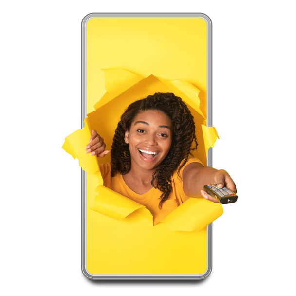 Excited African American Female In Cellphone Watching Television Pointing Remote Controller To Camera Through Hole Switching TV Channel Over White Studio Background. Collage, Square Shot - Photo, Image