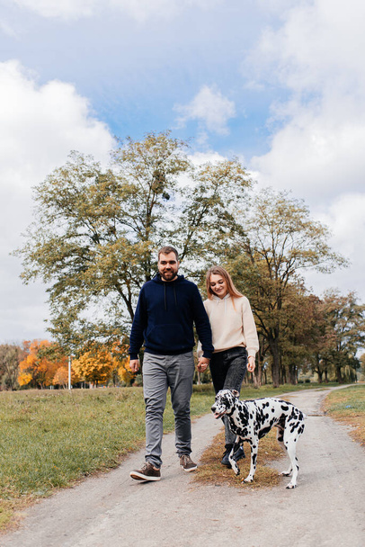 A happy couple walks their dog - Fotoğraf, Görsel