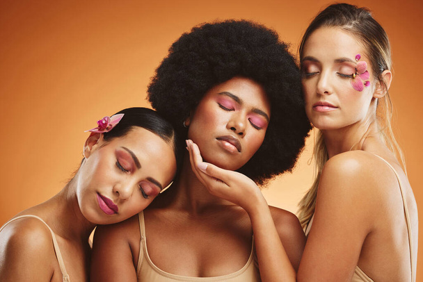 Beauty, diversity and skincare with a model woman friends in studio on an orange background for wellness. Health, skin and cosmetics with a female group posing to promote a product or treatment. - Photo, Image