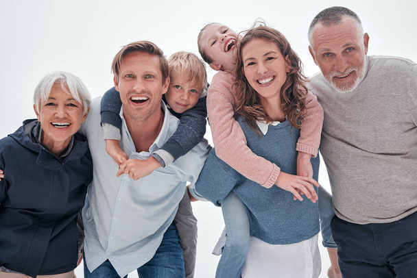Сім'я, щасливі і діти обіймаються смішним якісним часом з посмішкою і літніми людьми. Портрет старших бабусь і дідусів, батьків і дітей, які сміються з щастям, коханням і турботою, посміхаючись разом
. - Фото, зображення
