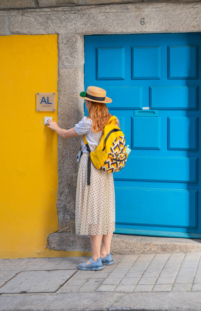 Hátsó kilátás turisztikai nő cseng a csengő az AL - Alojamento helyi - tipikus szállás Portugáliában. élvezi a nyaralást Európában. - Fotó, kép