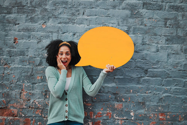 Social media, wow and woman with speech bubble against a wall in city for marketing, business and news. Portrait, happy and surprise face from girl with chat on a board and advertising communication. - Foto, Imagen