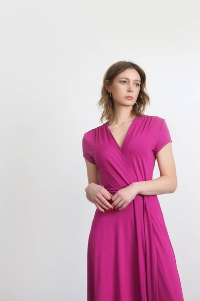 Série de photos studio de jeune mannequin femme en robe d'emballage rose vif. - Photo, image