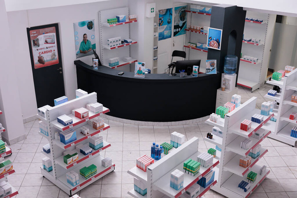 Empty pharmacy with nobody in it having shevles with pharmaceutical products, vitamin, supplements. Drugstore desk full with medical prescription of customers. Medicine support services - Photo, Image