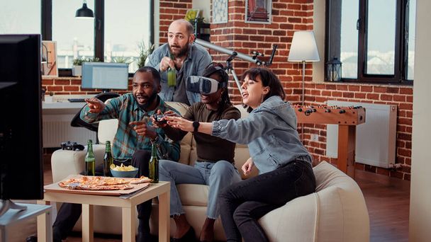 Sad group of friends losing online video games challenge using virtual reality glasses and television console. Feeling frustrated about lost game play competition at party gathering with beer. - Photo, Image