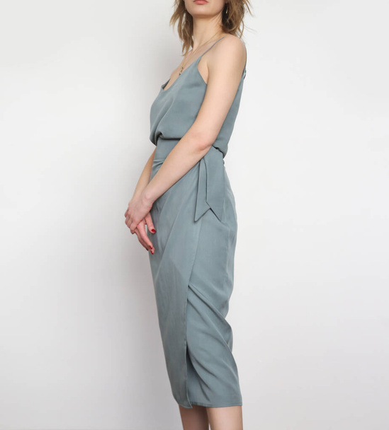 Modèle féminin portant un haut en soie camisole gris bleuâtre et une jupe midi enveloppée. Tenue d'été monochrome élégante. Prise de vue Fashion Studio. - Photo, image