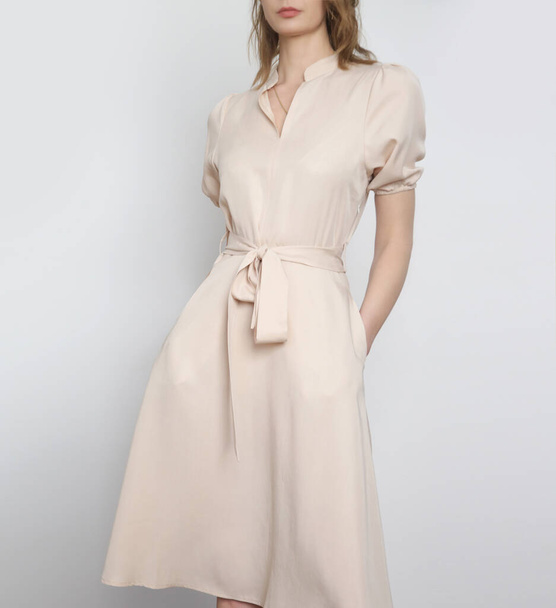 Studio shot of woman in classy simple beige viscose summer dress. - Zdjęcie, obraz