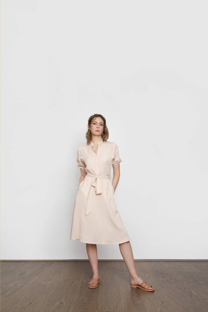 Studio shot of woman in classy simple beige viscose summer dress. - Foto, immagini