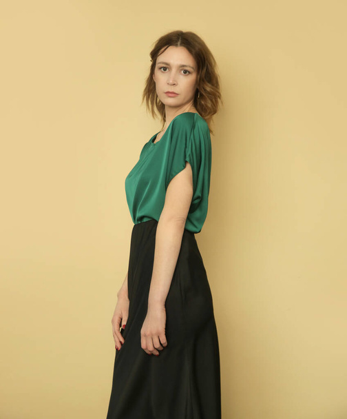 Serie of studio photos of young female model wearing green blouse and black skirt - Photo, Image