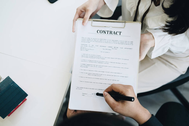 保証,抵当,契約,契約,署名,男性のクライアントは、不動産仲介業者や銀行の役員と土地の貸付け金に署名する契約書を読むためにペンを保持 - 写真・画像