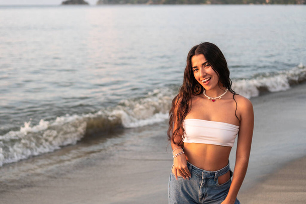 Retrato de uma bela mulher latina diversificada sorrindo na praia. Conceito de estilo de vida hispânico. - Foto, Imagem