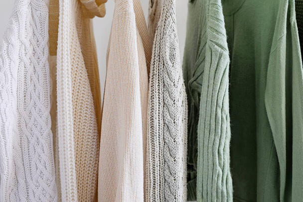 Porte-chandails tricotés près d'un mur léger, gros plan - Photo, image