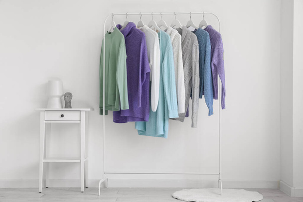 Porte-chandails tricotés près du mur de lumière dans la pièce - Photo, image