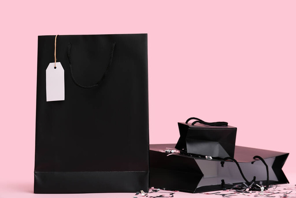 Shopping bags with confetti on pink background. Black Friday sale - Foto, Imagem