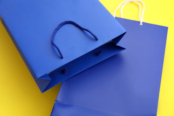 Blue shopping bags on yellow background, closeup. Black Friday sale - Photo, Image
