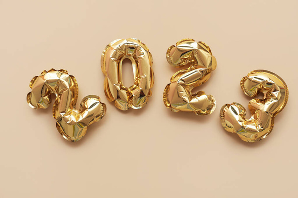 Figuur 2023 gemaakt van gouden ballonnen op beige ondergrond - Foto, afbeelding