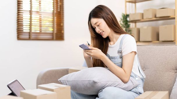 Woman uses mobile phone or tablet to chat with customers who come to order product, Freelance work at home, Conversation with customers through massage, Small business owner, SME entrepreneur. - Photo, image
