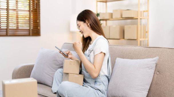 Woman was happy after receiving an order from an online customer, New business style for  people working at home and owning businesses, Online shopping SME entrepreneur, Packing box, Sell online. - Photo, image