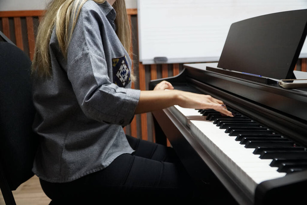 жінка вчиться грати на піаніно
 - Фото, зображення