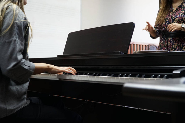 жінка вчиться грати на піаніно
 - Фото, зображення